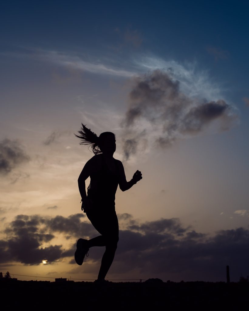 Jumping woman and sky with clouds at sunset